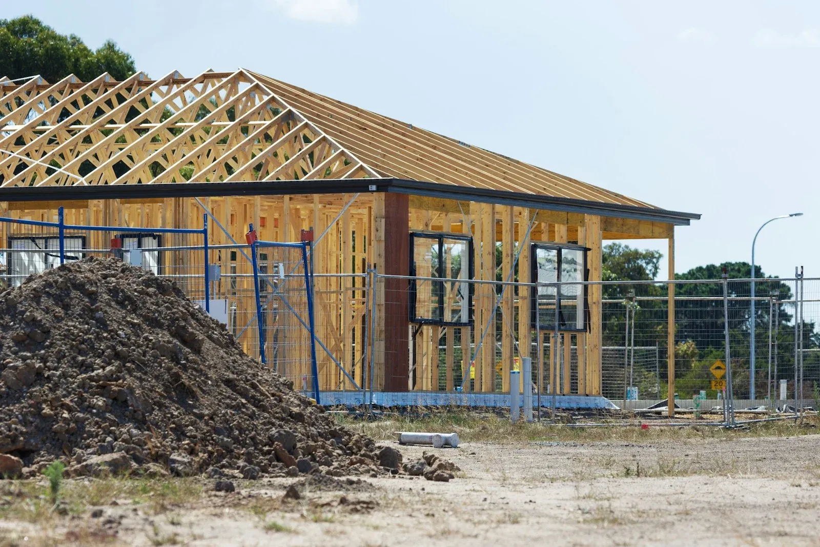 A building under construction with its roof trusses and wall framing exposed